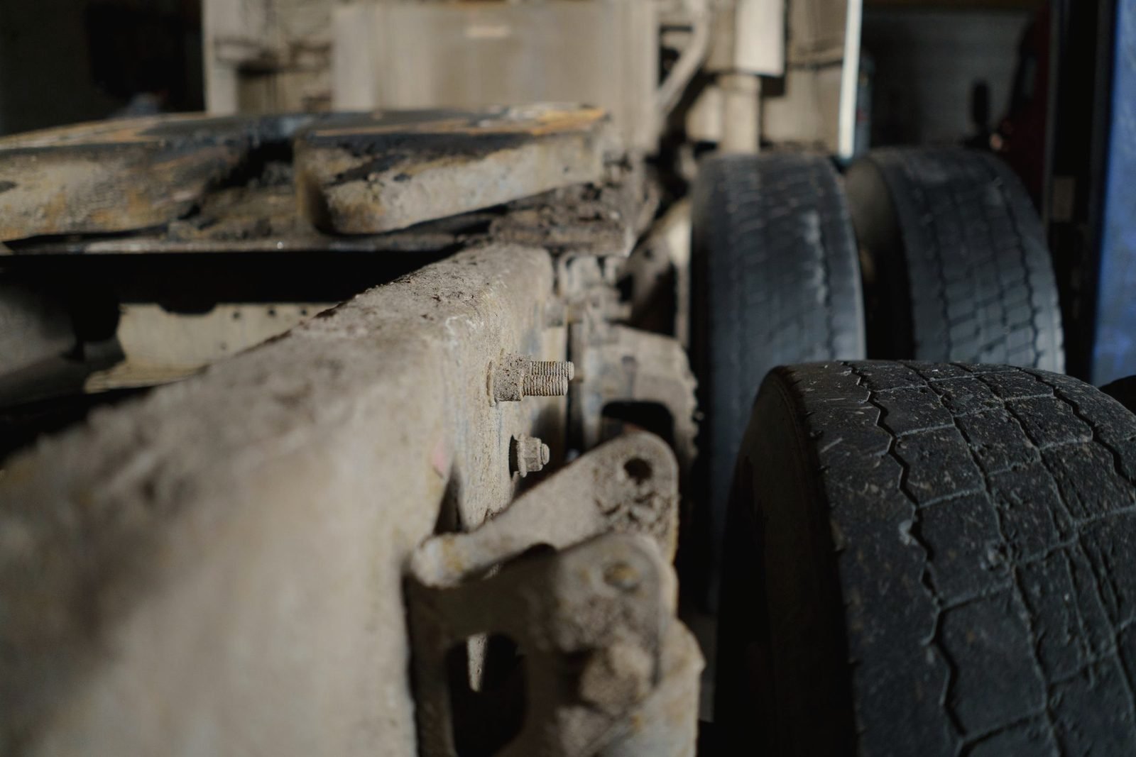 Dirty chassis rail and drive tires under a truck